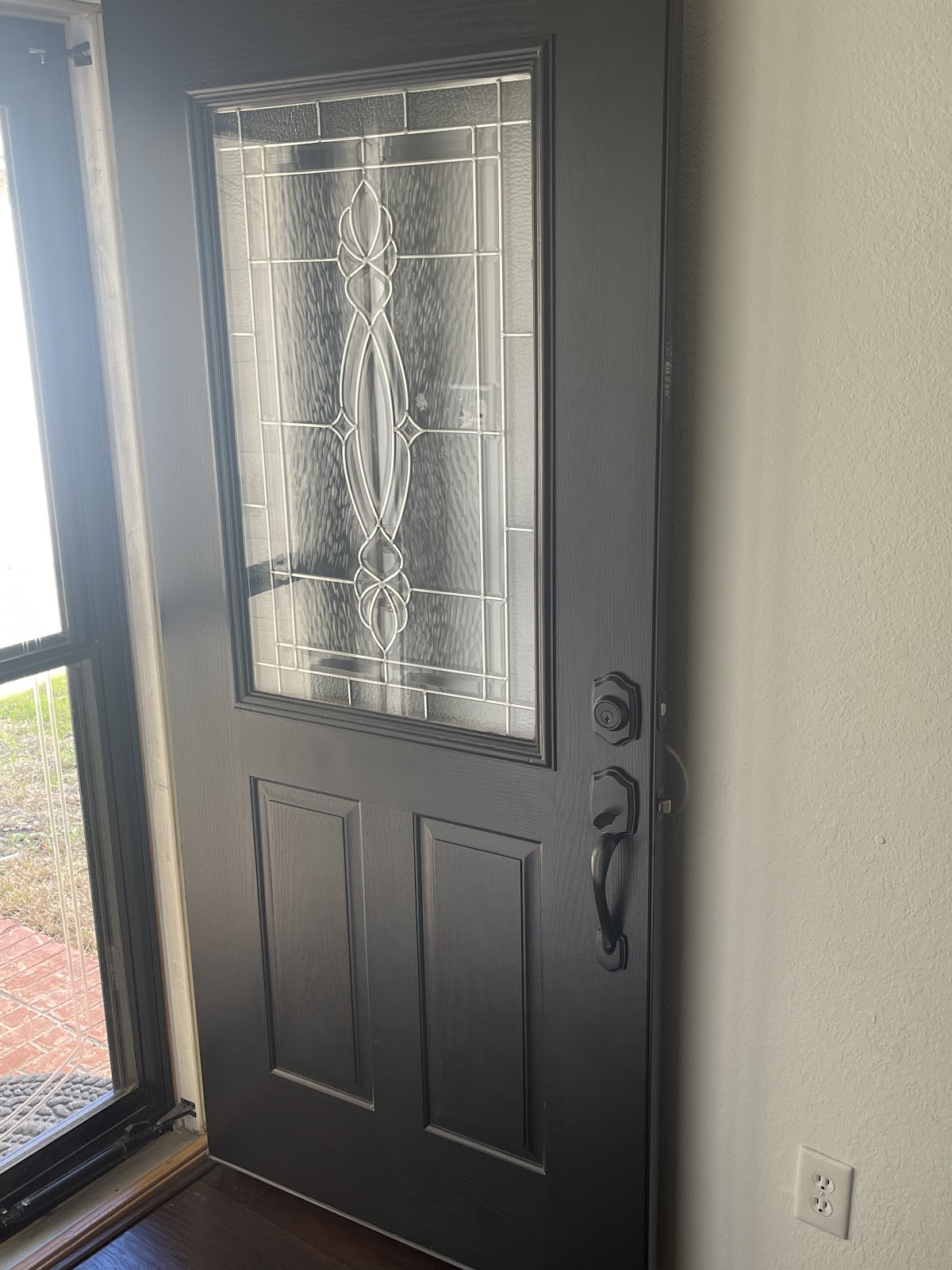 Front door painted dark grey with decorative glass